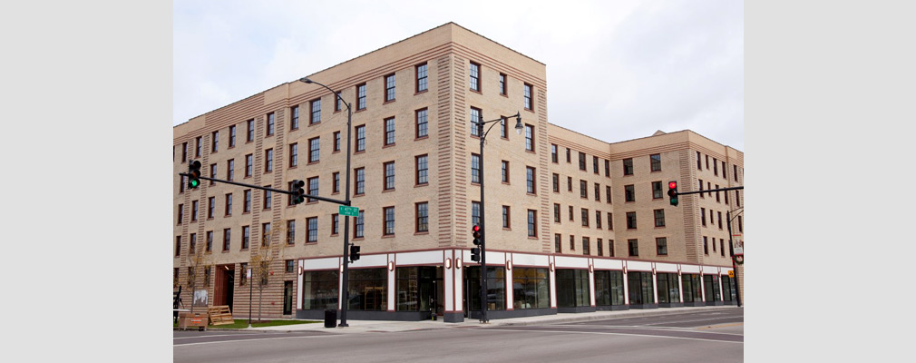 Photograph of two street façades of the 5-story mixed-use building with storefronts on the ground floor.