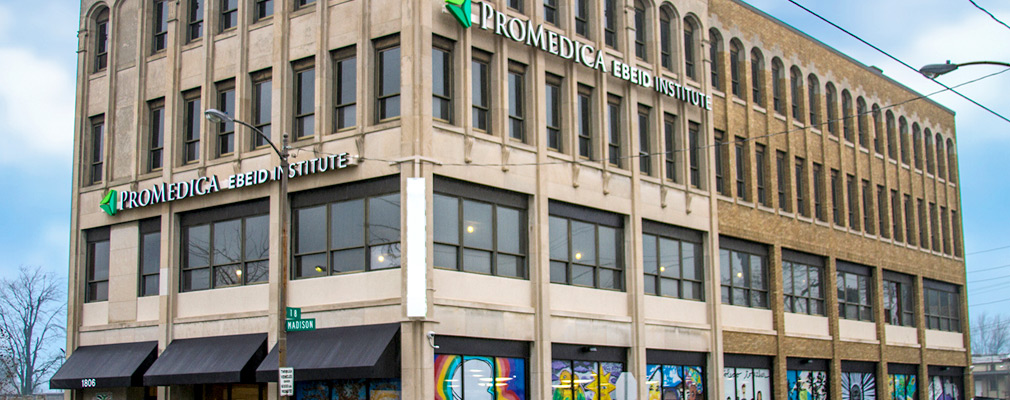 Photograph of the two street façades of a four-story commercial building.