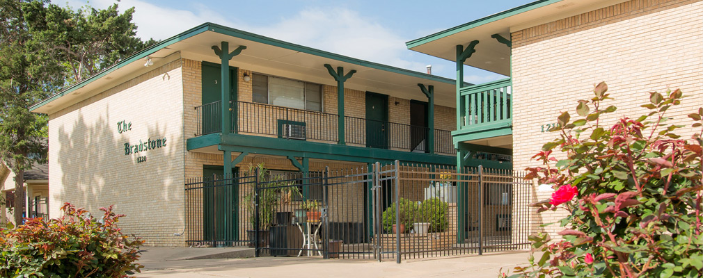 Photograph of two 2-story residential buildings facing each other across a courtyard.