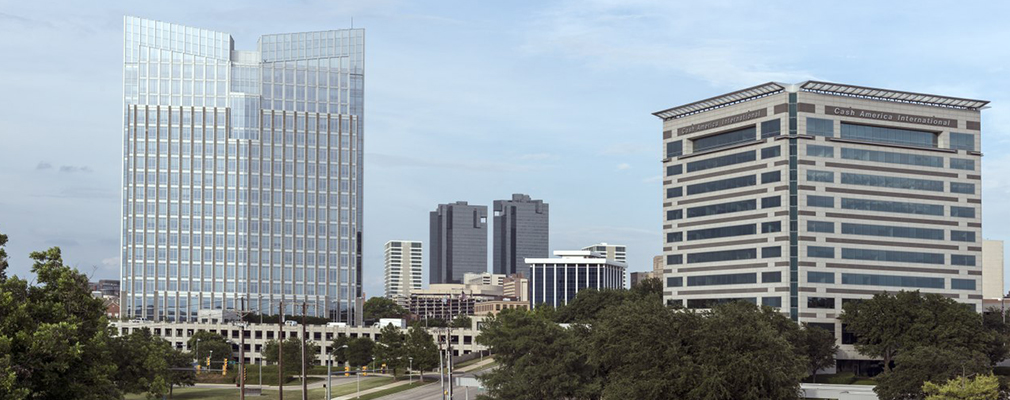 Photograph taken from the Clear Fork Trinity River corridor looking northeast toward several multistory buildings in downtown Fort Worth, Texas.