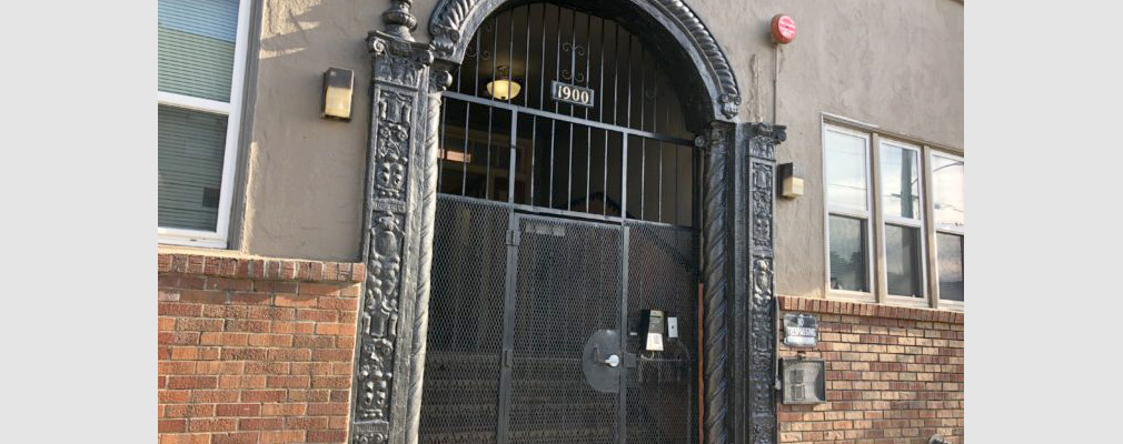 Photograph of the entrance to Kensington Gardens, with decorative and security ironwork.