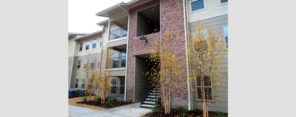 Photograph of a façade of a three-story apartment building.