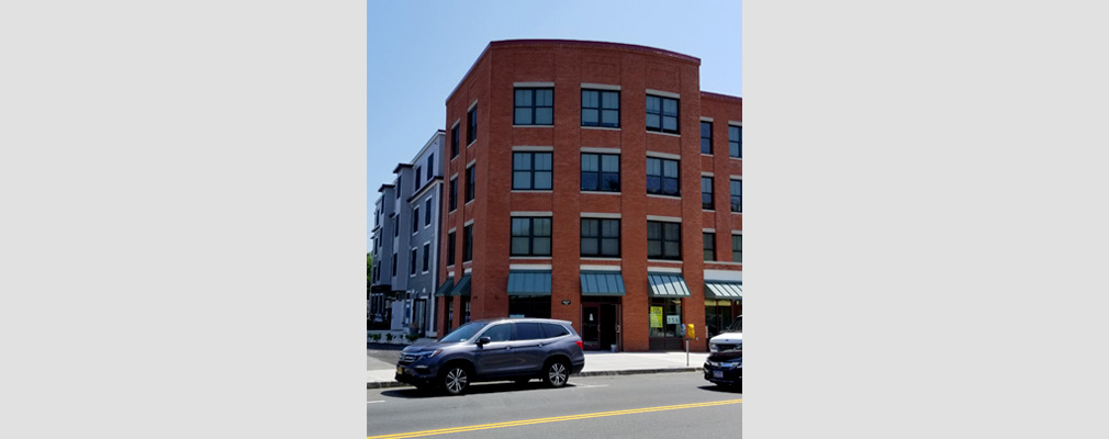 Photograph of the front façade of a four-story mixed-use building.