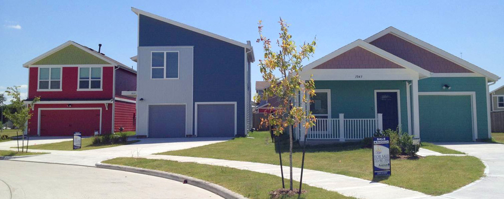 Photograph of three single-family detached houses with small front yards.