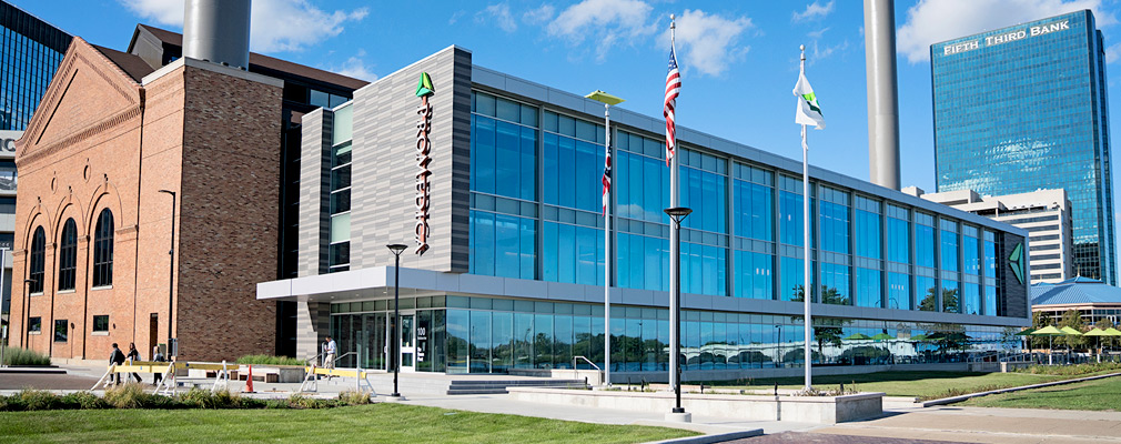 Photograph of a newly constructed three-story office building attached to a brick industrial building.