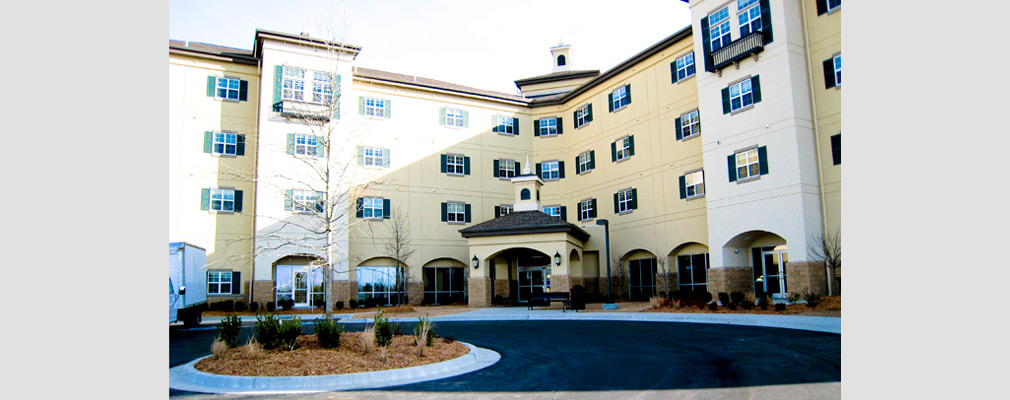 Photograph of the entrance to an L-shaped, four-story residential building.