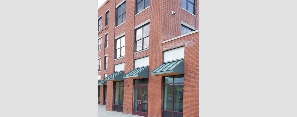 Photograph of a street façade of a four-story mixed-use building. 