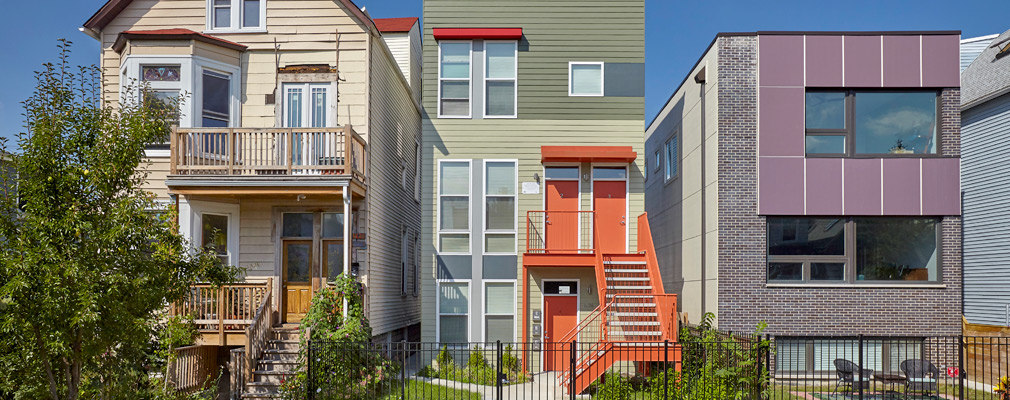 Photograph of the front façades of three 3-story houses, two of which have modern design features.