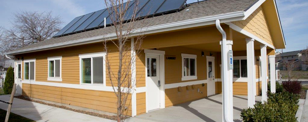 Photograph of a one-story building with solar panels on the roof.