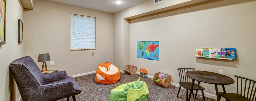 Photograph of a room with chairs, tables, and toys.