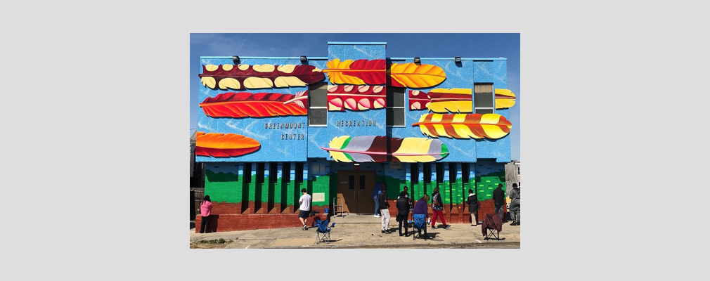 Photograph of the front façade of the Greenmount Avenue Recreation Center painted with a vibrant mural. 