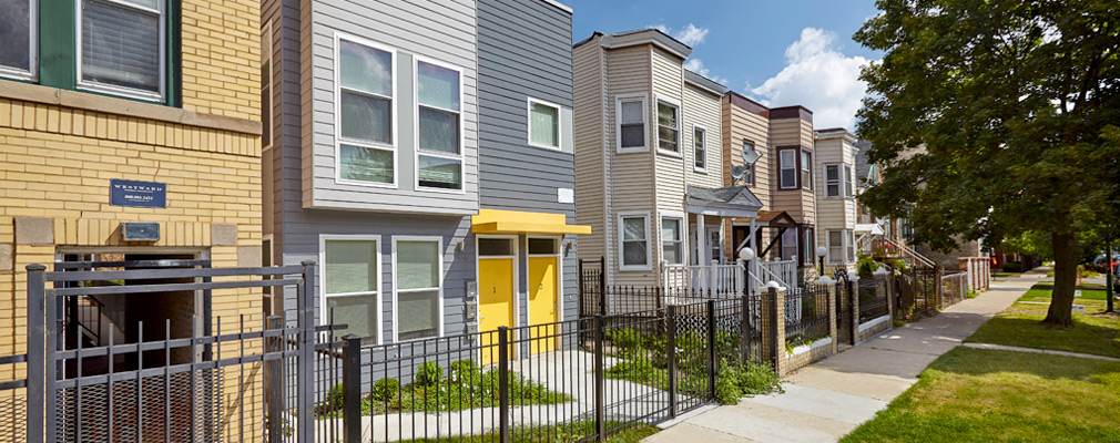 Photograph of the front façades of several houses with no steps or ramps leading to the front doors.