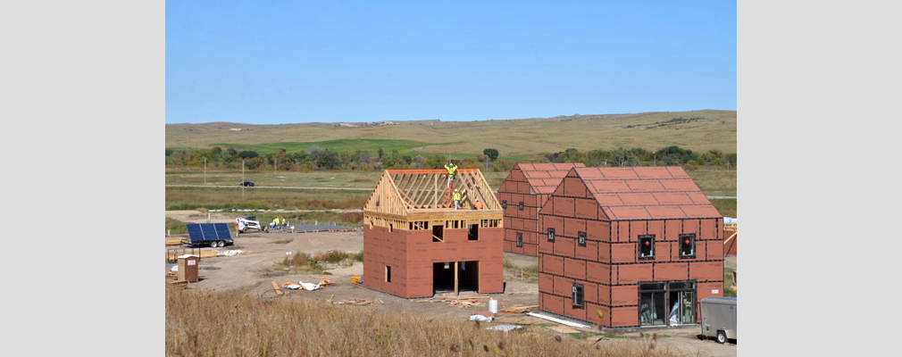 Photograph of three 2-story houses under construction.