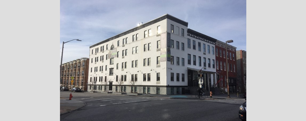 Photograph of two façades of a five-story building on a corner lot.