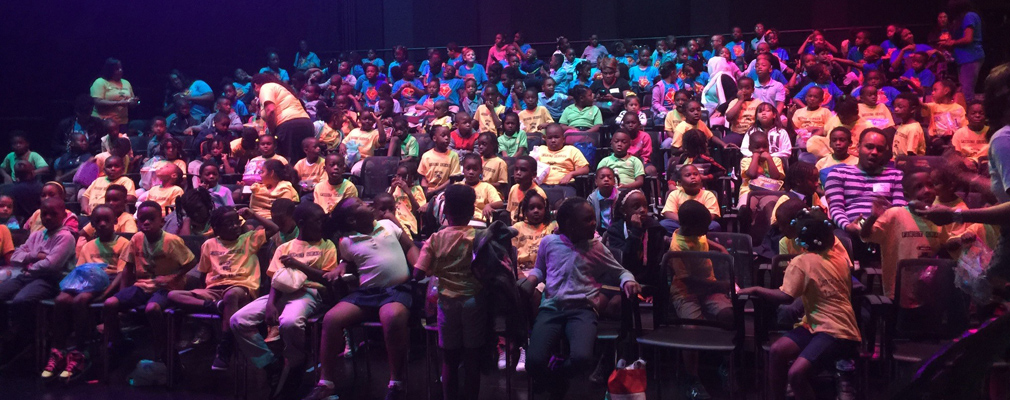 Photograph of a young audience seated in the Sandrell Rivers Theater.