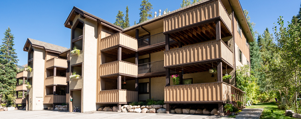 Photograph of the front and side façades of a three-story condominium building.