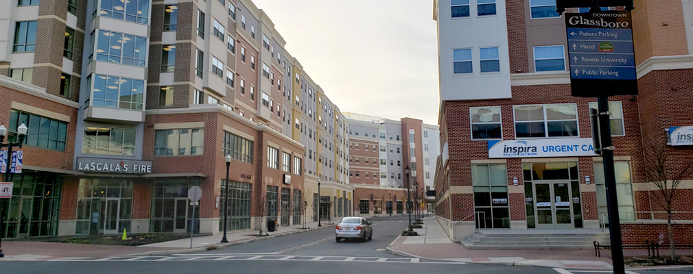 Photograph of five- and six-story mixed-use buildings along Victoria Street receding into the background, with the Rowan Boulevard intersection in the foreground.