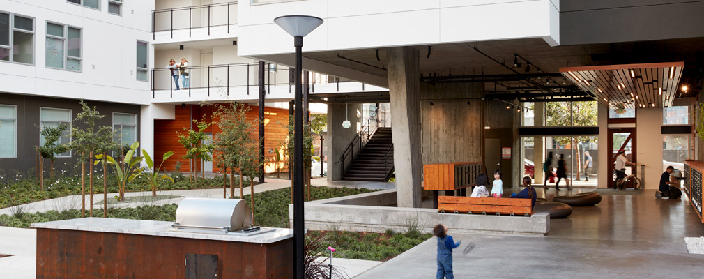 Photograph of a landscaped courtyard enclosed by a four-story building, with the lobby at the right edge of the photograph.