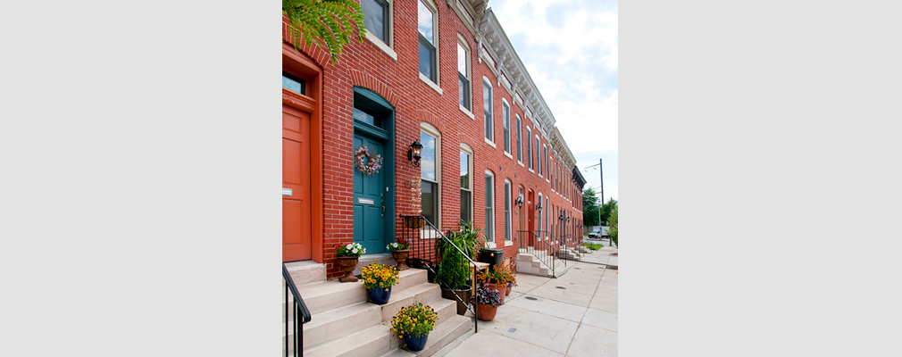 Photograph of several rehabilitated two-story brick rowhouses. 