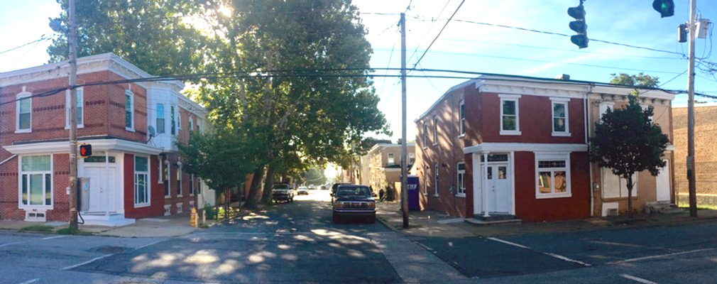 Photograph of rehabilitated two-story rowhouses on two corner lots.