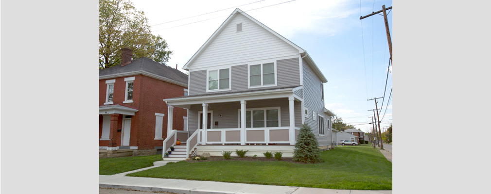 Photograph of a two-story single-family house in good repair, beside a similar house in poor condition. 