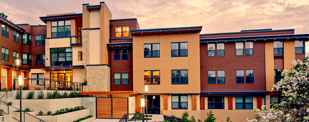 Photograph of the façade of a multistory multifamily building. 