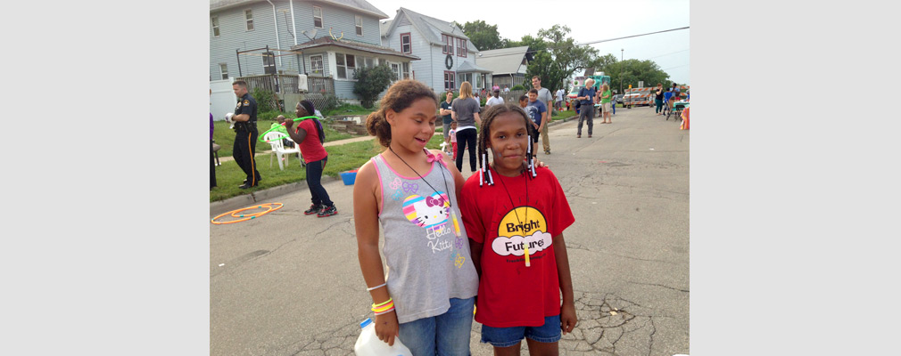 Photograph of two children at a neighborhood block party. 