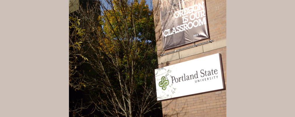 Photograph of a building on the PSU campus with the university’s logo and a sign stating, "Oregon is our classroom." 