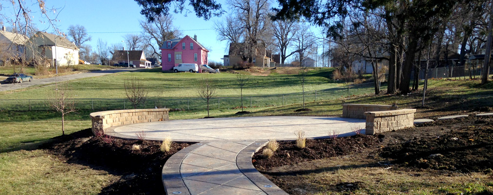 Photograph of a stone path and sitting area in a park. 