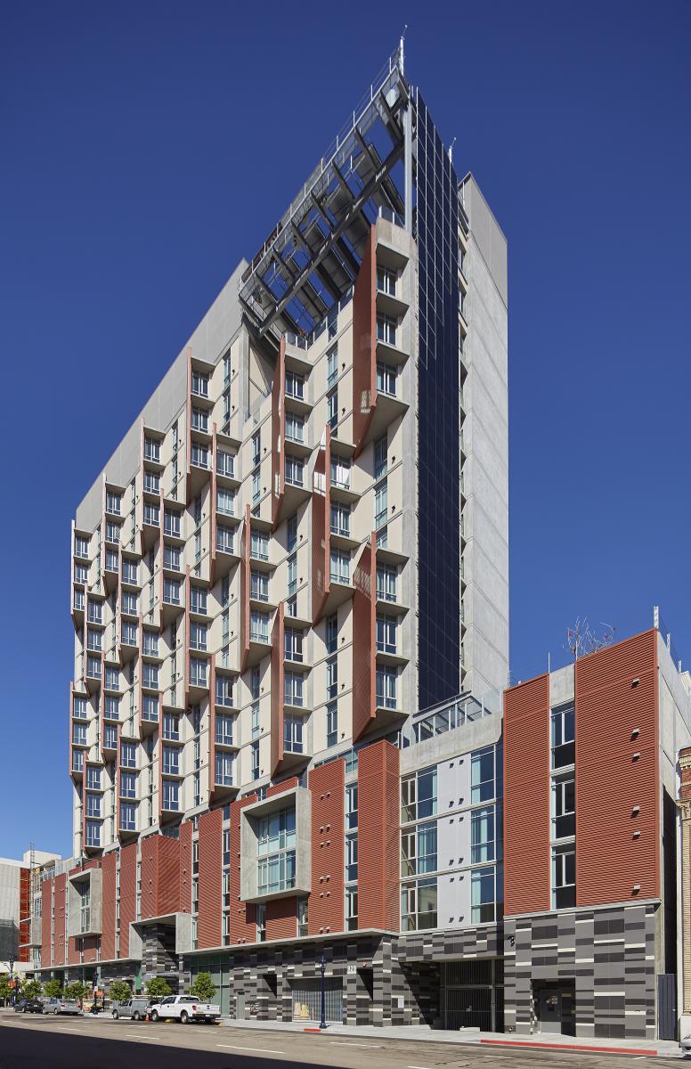 Photograph of the southern and western façades of a 17-story multifamily building.