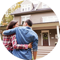 Happy couple hugging each other infront of a house