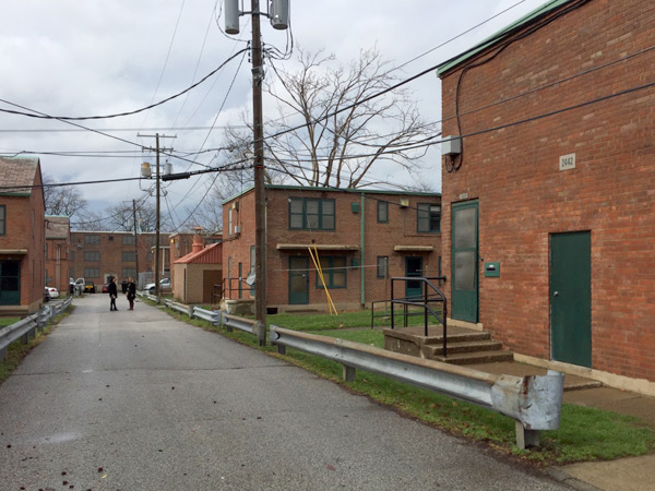 Image showing rows of brick, multifamily housing units along a street.