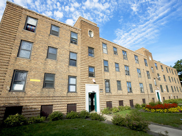 Image of a three story multi-family apartment building with a brick façade. 