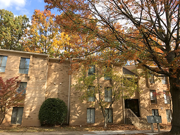 Photograph of the of a three-story multi-family residential building with a brick façade.