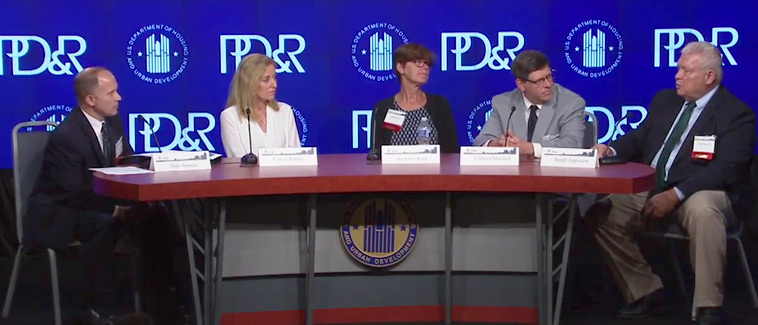 General Deputy Assistant Secretary for PD&R Matt Ammon and four panel participants sit behind a table in front of a background with the PD&R logo.