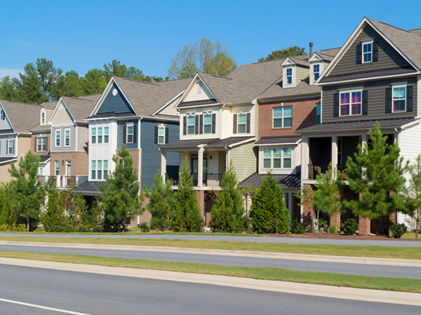 Photograph of multi-story, attached residences with varied façades along a street.