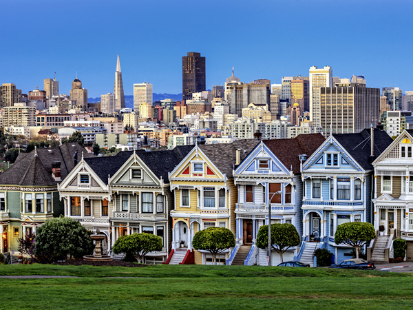 Image of San Francisco showing brightly painted homes in the foreground and the downtown skyline in the background.