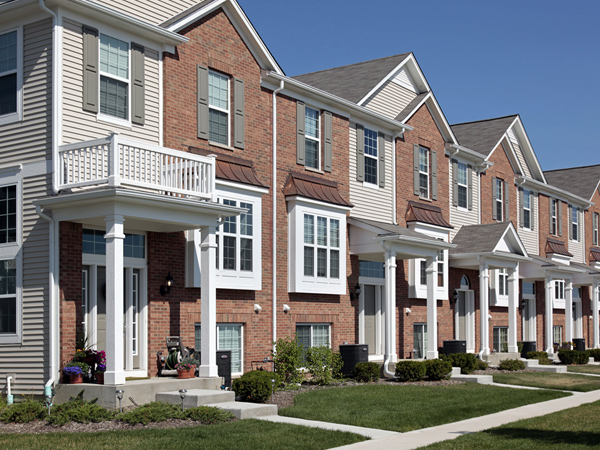 Multistory townhomes with brick and siding façades.