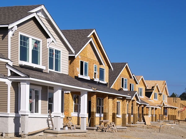 Photograph of a row of two-story, single-family houses that are under construction.
