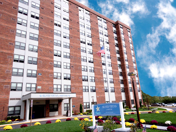 Image of a 14-story residential building with a sign stating “Silver Vistas” in the foreground.
