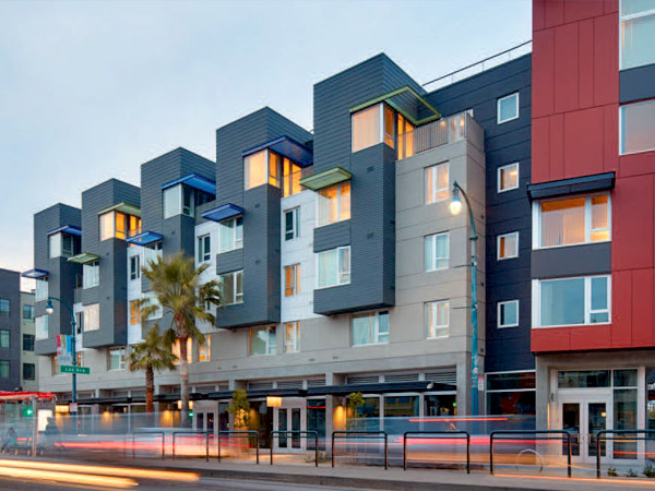 Image of a 5-story multifamily residential building with ground floor retail along a city street.