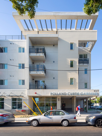 Image of a four-story commercial and residential building in an urban area.