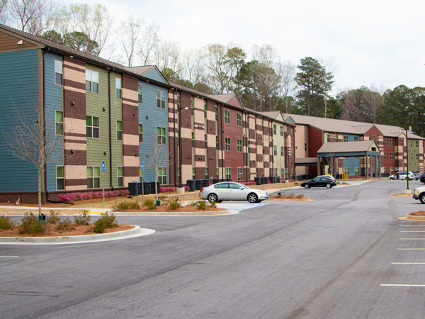 Image of a three-story, multicolored apartment building.