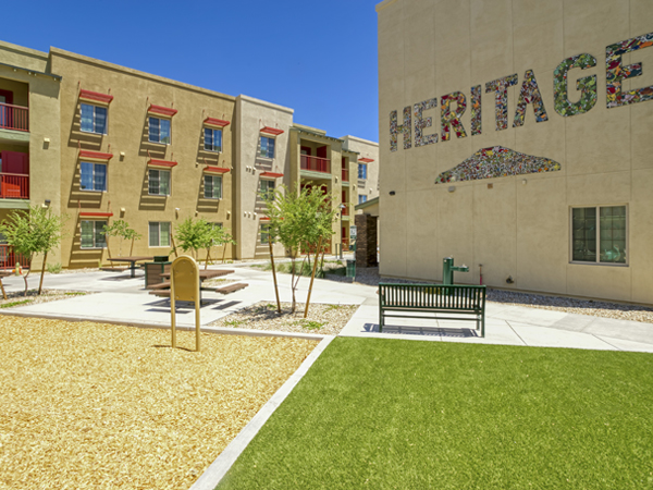 Photo of two buildings and a courtyard with benches in the foreground.