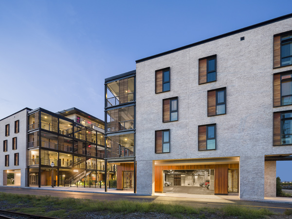 Image of a four-story U-shaped building lit at twighlight.