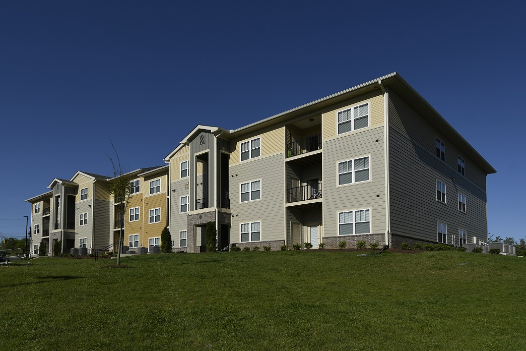 Photograph of a three-story apartment building surrounded by lawn.