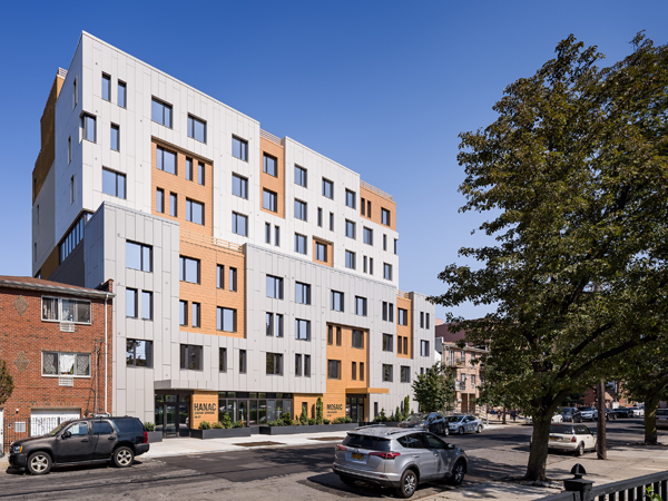 Photograph from the street of the exterior of the 8-story HANAC Corona Senior Residence.