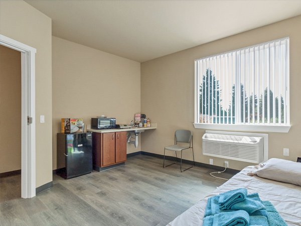 An image of a bedroom with a kitchenette.