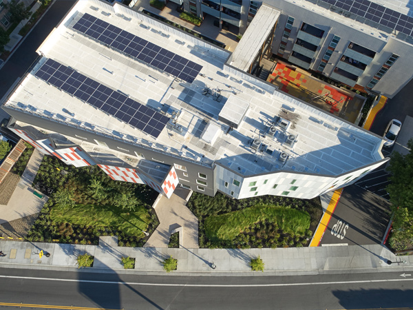 Aerial photo of an apartment building with solar panels on the roof.