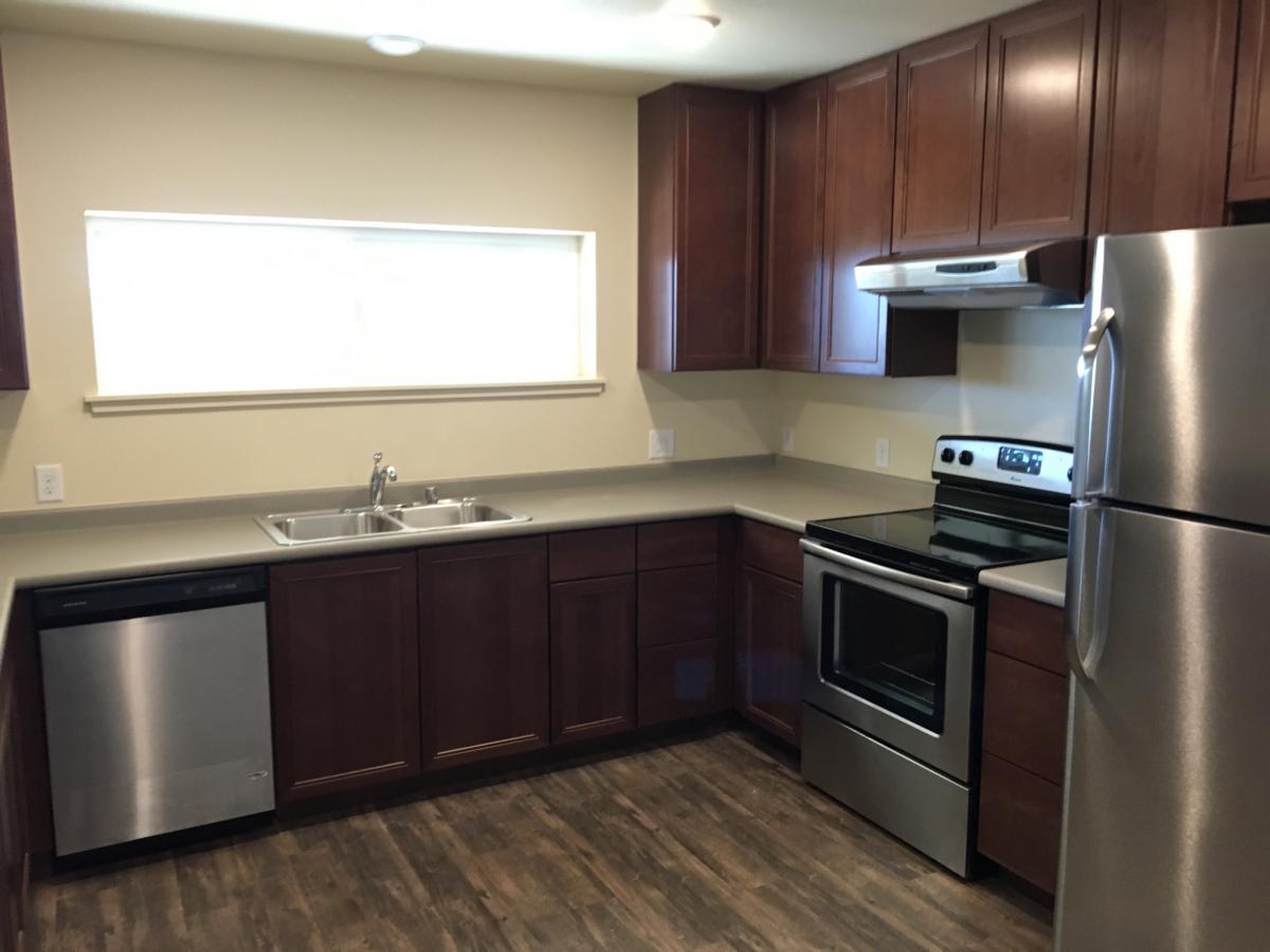 An unfurnished kitchen with a large window.